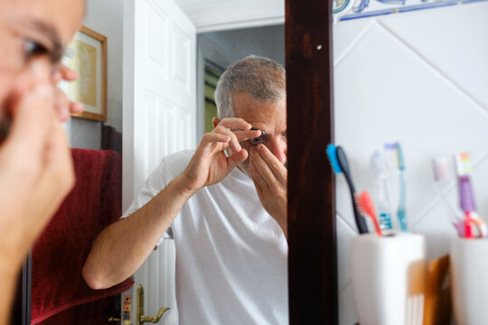 Crop of Man putting contact lenses