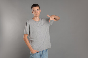 Teenage boy wearing t-shirt on grey background