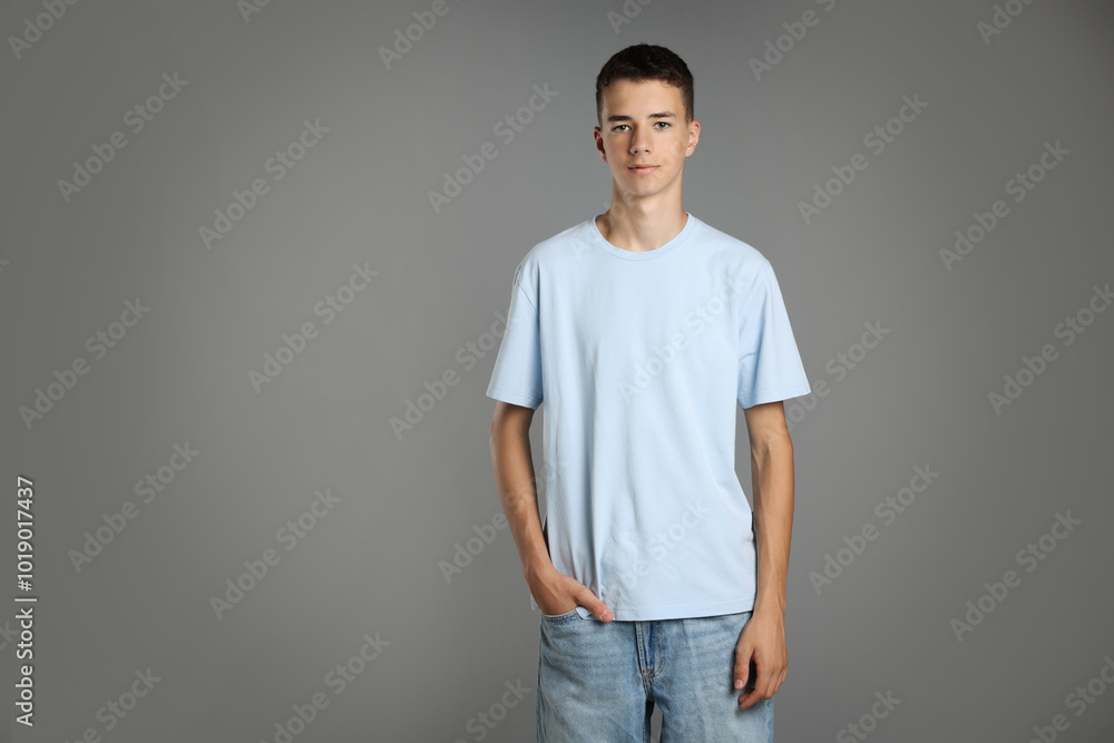 Canvas Prints Teenage boy wearing light blue t-shirt on grey background, space for text