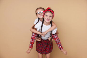 Portrait of cute little sisters on beige background