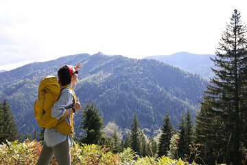 Young hiker with backpack in mountains on sunny day