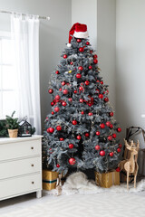 Obraz premium Interior of living room with decorated Christmas tree, chest of drawers, fireplace and gift boxes