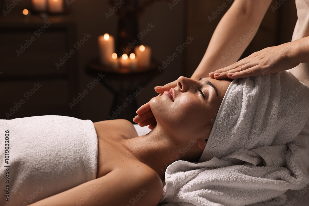 Wall mural Attractive woman enjoying face massage in spa salon, closeup