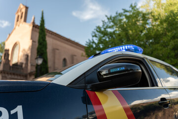 Spanish police car parked outside a church on a sunny day © Jorge