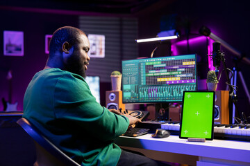 Professional music producer editing his songs to enhance sound quality, mixing and mastering tunes...