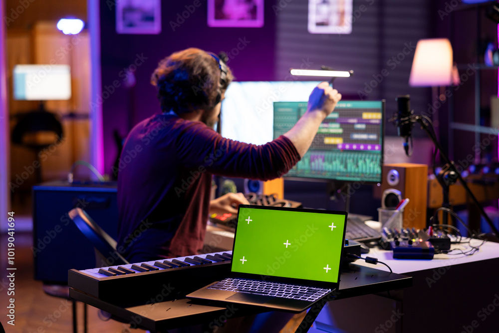 Leinwandbilder sound engineer enhancing volume levels on daw software, editing soundtracks next to laptop showing i