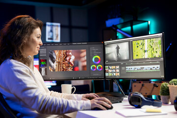 Smiling video editor using editing software to upgrade footage shot, commissioned by production...