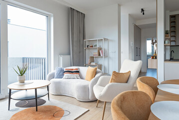 Cozy interior of living room with comfortable sofa and armchair in new apartment. Design home with window.