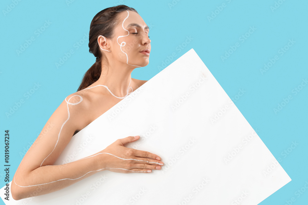 Wall mural Young woman with painted body and blank poster on blue background