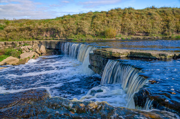 Tosnensky (Hertovsky) waterfall on a sunny October day. Leningrad Region