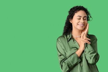 Beautiful young African-American woman on green background. International Women's Day