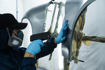 Using anti static gun to prevent damages and remove dust before covering car with paint. Mechanic...