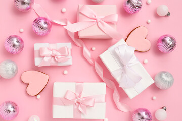 Christmas gift boxes with balls, cookies in shape of heart and ribbon on pink background
