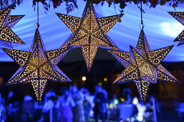 tres estrellas navideñas de latón en entorno azul 