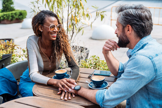 Couple enjoying coffee and conversation at an outdoor cafe