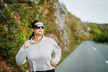 Young caucasian woman running or jogging on the country road	