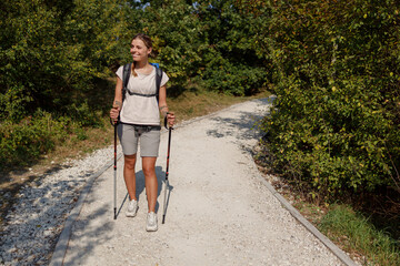 A Hiker Truly Enjoying the Beautiful Nature While Trekking on a Scenic Trail with Walking Poles