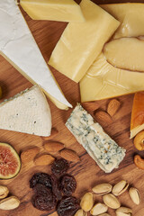Round board with a wide variety of cheeses and other products to accompany a glass of red wine