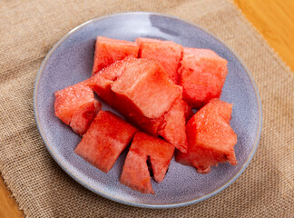 Ripe watermelon divided in pieces served in a plate with necessary table laying