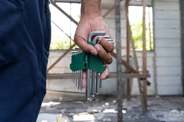 Mechanic's Hands Holding Allen Wrench Set