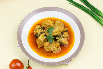 Ayam rica-rica, Indonesian traditional spicy chicken with spicy sauce and basil leaves. Isolated background.