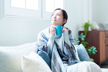 リビングで休む女性　寒い　悪寒　寒暖差アレルギー