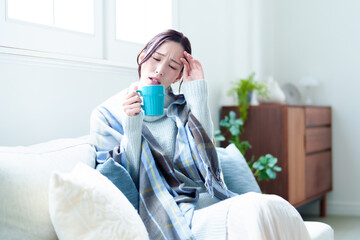 リビングで休む女性　寒い　悪寒　寒暖差アレルギー