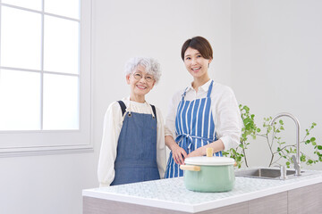 キッチンでエプロンをした親子のポートレート