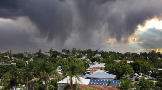 Heavy tropical storm clouds and rain over the city of Brisbane, Queensland, Australia with beams of sunlight