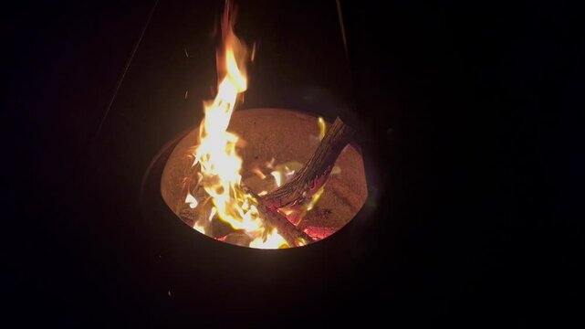Orange flame bonfire fire burning in the dark outdoor.