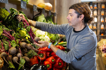 Caucasian man looking to buy beet in local vegetable market