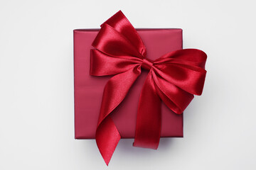 Gift box with bow on light grey background, top view