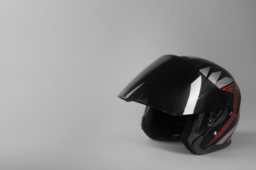 Motorcycle helmet with visor on light grey background, space for text