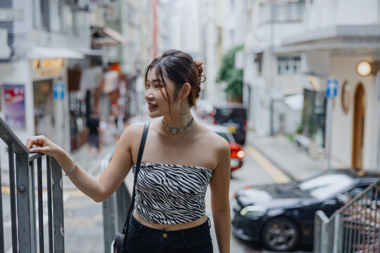 Woman in Zebra Print Top Standing by a Railing in the City