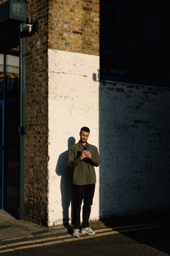 A tourist uses his smartphone to photograph the streets of Dalston