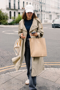 Tourist using her phone during a shopping trip to Notting Hill, London