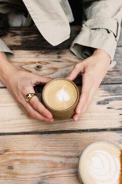 Unidentified woman holding a cup of coffee with latte art
