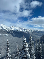 Snow-covered Rocky Mountains viewed from Banff Gondola in Alberta, under clear blue sky
