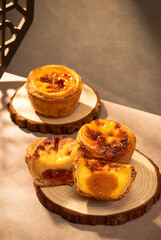 Sunlight shining on egg tarts, wooden dining table and tableware indoors