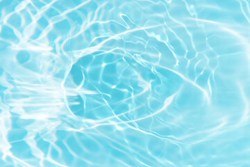 Blue water with ripples on the surface. Defocus blurred transparent blue colored clear calm water surface texture with splashes and bubbles. Water waves with shining pattern texture background.