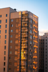 High rise community housing on sunset with sun reflection.