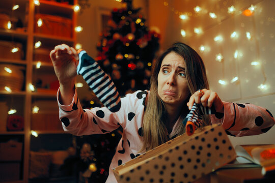 Displeased Woman Receiving Socks as Christmas Present. Person displeased with her bad Xmas present feeling awkward 
