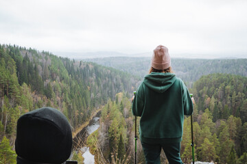 An adventurous hiker is enjoying a beautiful and scenic overlook situated amidst a lush and vibrant...