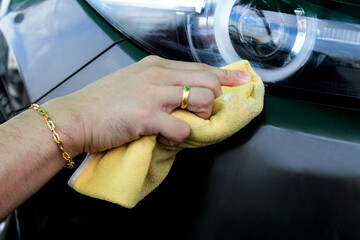Cleaning the car by using a cloth that prevents dust. © Idsaree