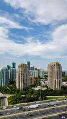 Aerial views of high-rise residential buildings near the 401 expressway and Yonge Street in Toronto. The bustling highway, surrounded by lush greenery and modern architecture, creates a dynamic