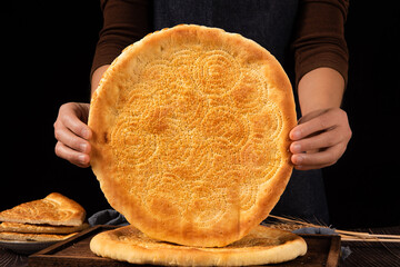 hand holding a naan bread, Traditional food in Xinjiang, China