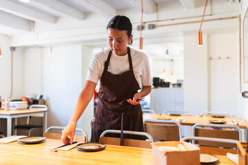 Young Employee Setting Up Table in Korean Restaurant