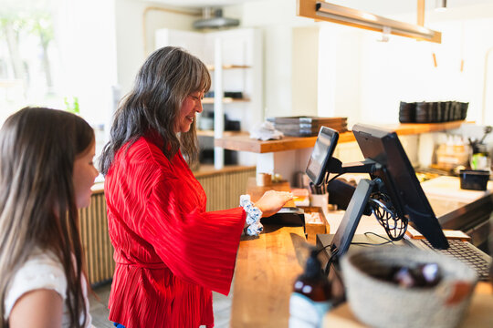 Mother and Daughter Paying with Credit Card at Cash Register