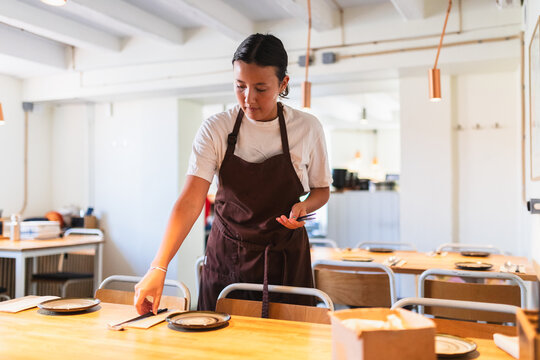 Young Employee Setting Up Table in Korean Restaurant