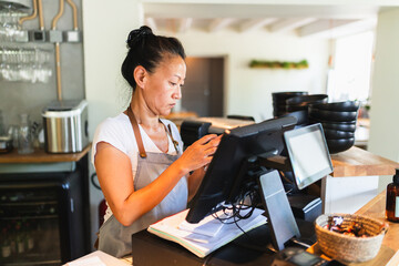 Small Business Owner Working at Cash Register in Korean Restaurant